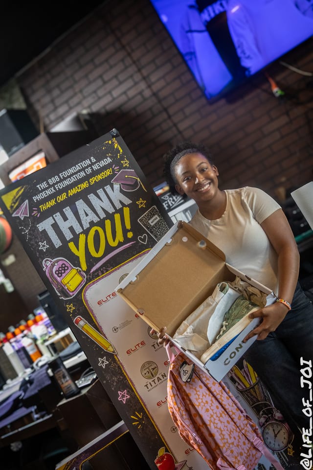 A student opens a box of new Converse sneakers donated through the 888 Fresh Start Experience.