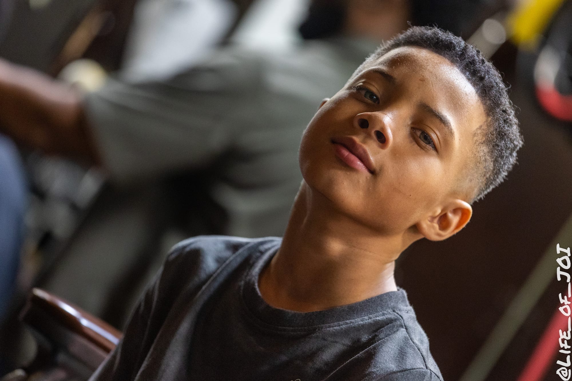 A student looks up with a sharp fresh fade after his free haircut at the 888 Fresh Start Experience.