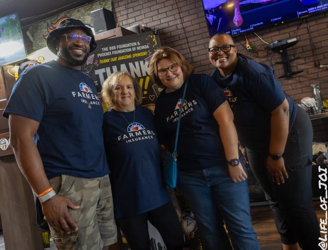 Volunteers from Farmers Insurance gather at the sponsor banner during the 888 Fresh Start Experience.