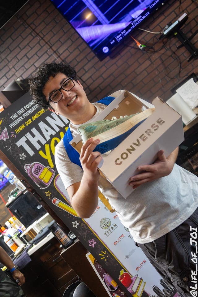 A smiling student carries his new sneakers away from the giveaway table.